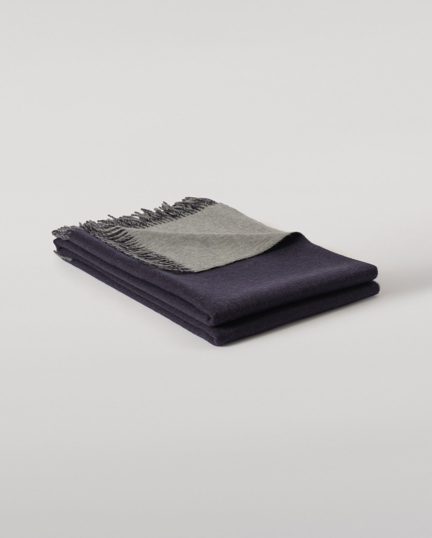 Johnstons of Elgin Interiors Collection  Reversible Navy & Light Grey Cashmere Throw on a wooden chair  WA000013RU6632N/A