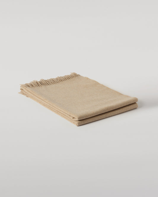 Johnstons of Elgin Interiors Collection Oatmeal Cashmere Throw on a wooden chair WA000055HB0210ONE