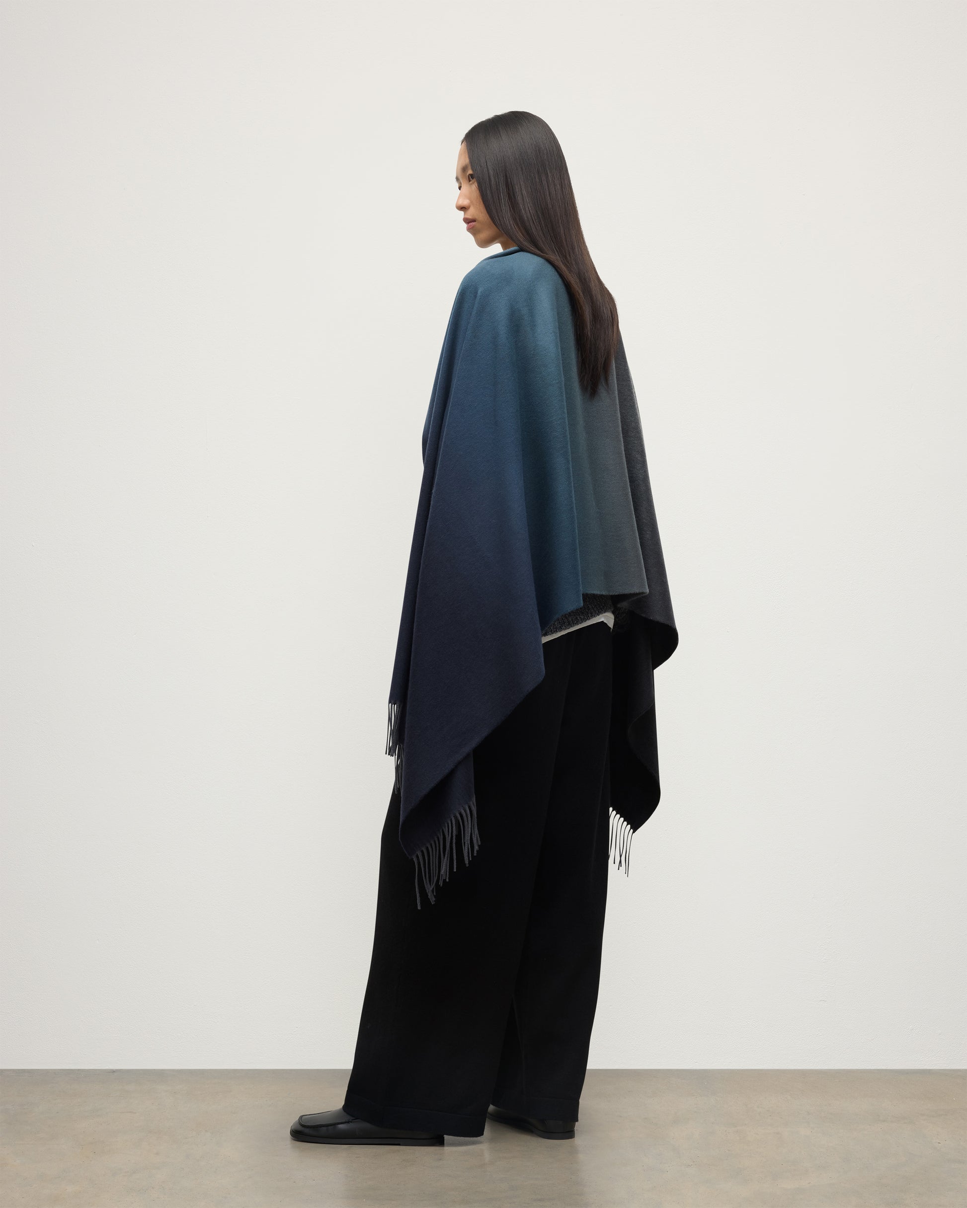 FEMALE MODEL WEARING JOHNSTONS OF ELGIN UMBRA OMBRE STOLE BLACK & NAVY 100% CASHMERE OVER BLACK CASHMERE KNITWEAR WA000056RU7302ONE
