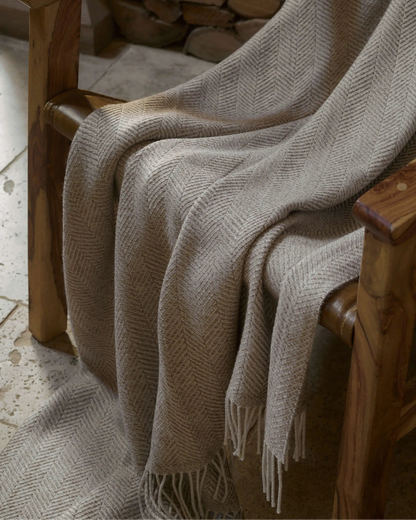 2025 Johnstons of Elgin Interiors Collection Natural Texture Herringbone Merino Throw on a wooden chair WD001221RU7455ONE